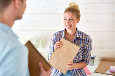 Yeni projeler noktaları tartışırken onun erkek meslektaşı bakarak not defteri ile Pretty rahat kız