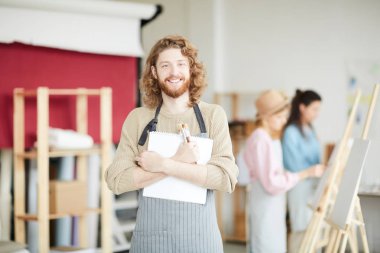 Başarılı bir öğrenci sanat dersi size bakarken göğsünden malzeme tutan