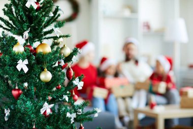 Tatil için beyaz ipek yay ve dekoratif oyuncak topları ile dekore Noel ağacı