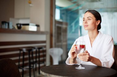 Kokteyl ve zevk zaman spa merkezi olan genç kadın kafe, yuvarlak masa başına oturmuş bornoz