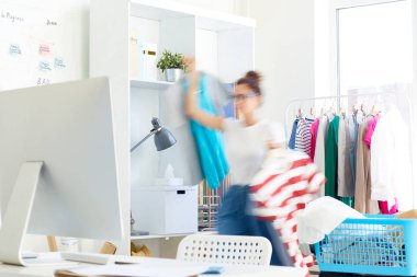 Çekim için acele ederken ofis içinde hareket giysi paketi ile Moda tasarımcısı veya stilist