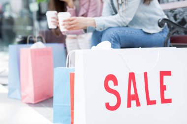 Satılık ile büyük paperbag fark kalan arka plan üzerinde sahip shopaholics ile
