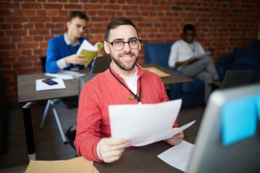 Ofiste kamera önünde işyeri başında otururken kağıtları demet ile başarılı ekonomist