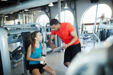 Afroamerican spor eğitmen genç aktif kadın online video veya vlog gösterilen ve onu izlemek için tavsiye tablet ile