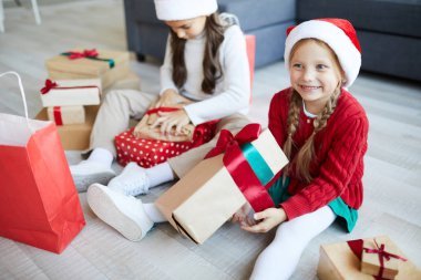 Büyük hediye kutusu ile mutlu sevimli küçük Santa yakın kız kardeşi ile katta oturan