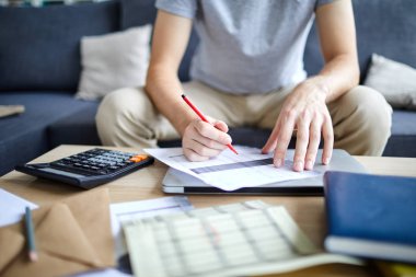Finans belgesi veya ödeme faturasında kırmızı fosforlu işaretli genç adam