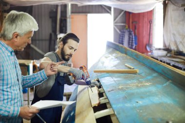Sondaj çalışmaları sırasında genç stajyerine talimat veren kağıtlı kıdemli mühendis