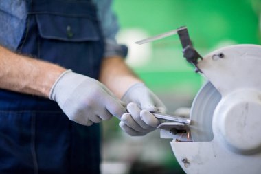 Otomatik parlatma makinesinde işleme sırasında çelik detay tutan fabrika mühendisieldivenli eller