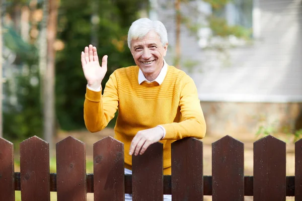 Cheerful Senior Man Casualwear Standing Wooden Fence Waving His Hand — Stock Photo, Image