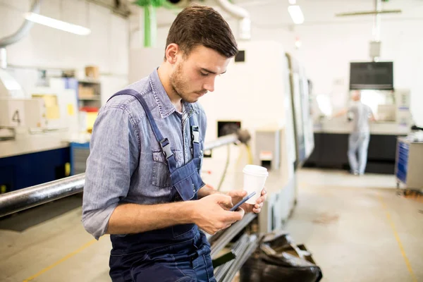 Junger Ingenieur Mit Handy Und Kaffee Sms Der Werkstatt — Stockfoto