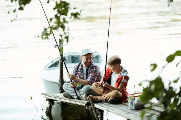 幸せな父親は 夏休み中に桟橋や釣りに彼の息子と一緒に座って — ストック写真