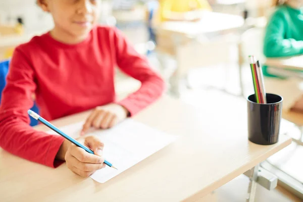 授業中に鉛筆を持ち 紙に書き込む男子生徒のクローズアップ — ストック写真