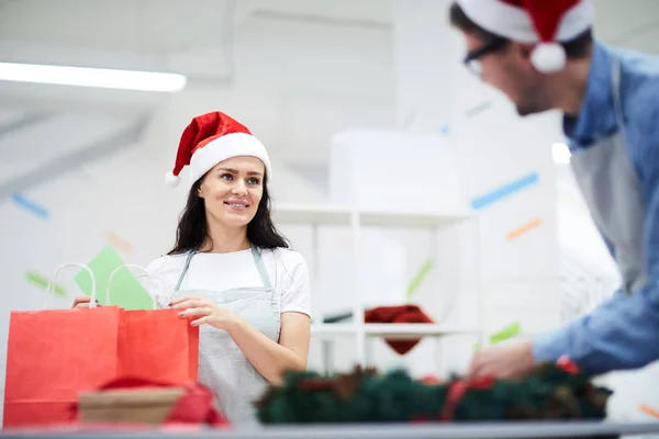 Gelukkig Positieve Jonge Medewerkers Santa Hat Praten Terwijl Kerstcadeaus Maken — Stockfoto