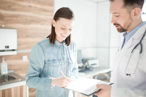 Glückliche Junge Frau Unterschreibt Ärztliches Dokument Mit Rezepten Und Notizen — Stockfoto