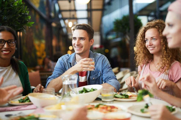 Tres Jóvenes Sentados Junto Mesa Servida Cenando Comunicándose Con Amigos —  Fotos de Stock