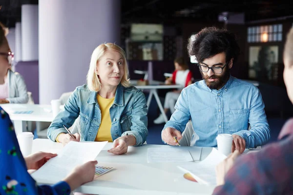 Dois Colegas Trabalho Sentados Mesa Deles Fazer Notas Trabalho Enquanto — Fotografia de Stock