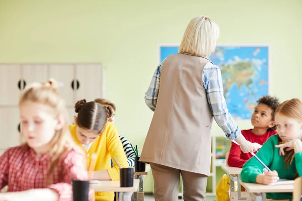 Rear View Teacher Moving Desks Commenting Mistakes Students While Passing — Stock Photo, Image