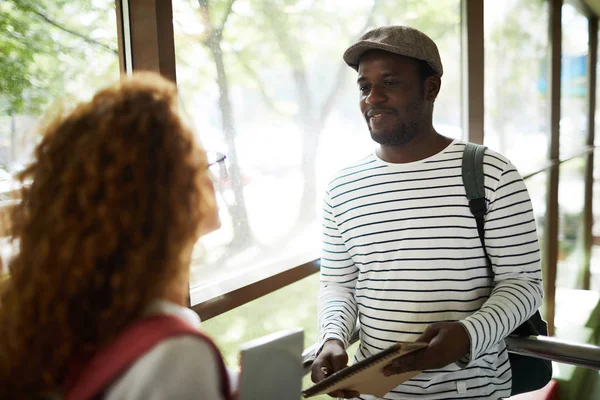 Afrikalı-americn adam casualwear üniversitede mola kız arkadaşı onun grup arkadaşı ile konuşurken