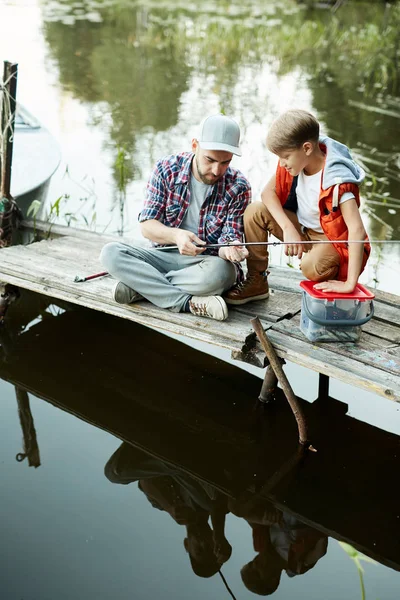 Jovem Mostrando Nova Vara Pesca Para Seu Filho Enquanto Ambos — Fotografia de Stock