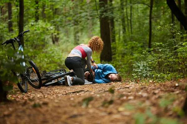Jovem Esportista Inclinando Sobre Ciclista Masculino Com Perna Quebrada Caminho — Fotografia de Stock