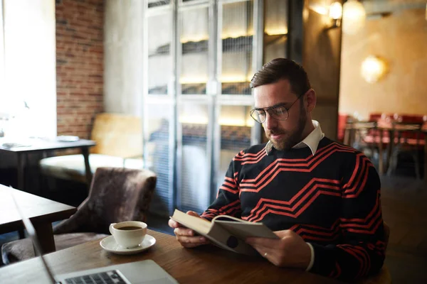 Vilsam Man Casual Tröja Sitter Vid Bordet Café Läsa Bok — Stockfoto