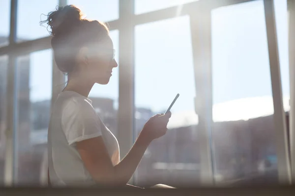 Mensagens Mulher Negócios Sérias Seu Smartphone Escritório Contra Luz Solar — Fotografia de Stock