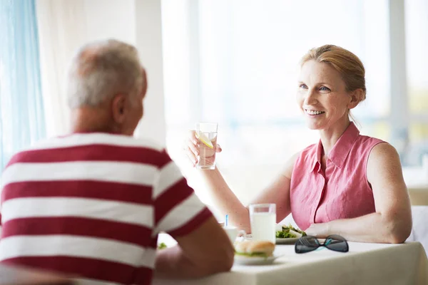 Mujer Sonriente Con Vaso Limonada Sentada Junto Mesa Frente Marido — Foto de Stock