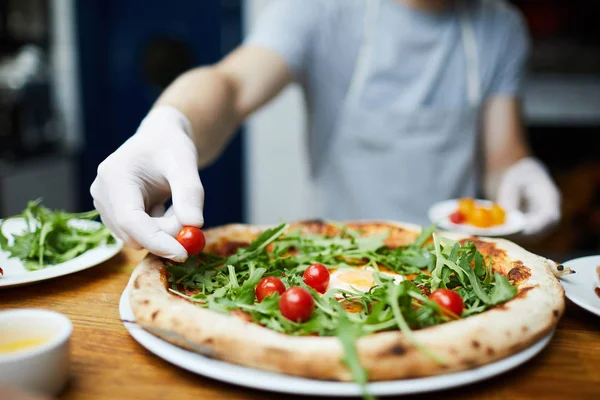 Baker Handskar Sätta Körsbärstomater Ovanpå Kokta Pizza Som Dekoration — Stockfoto