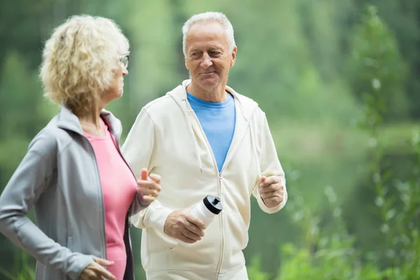 Active Senior Man Bottle Water Looking His Wife While Jogging — Stock Photo, Image