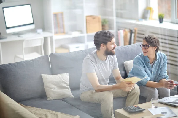 Junges Paar Sitzt Auf Dem Sofa Und Bespricht Sein Familienbudget — Stockfoto