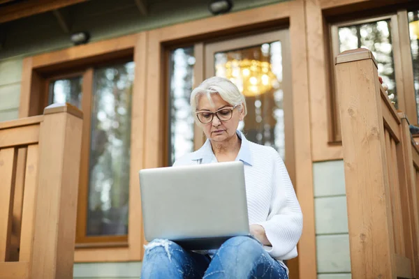 Σοβαρή Ώριμη Γυναίκα Laptop Κάθεται Στην Βεράντα Και Αναζήτηση Για — Φωτογραφία Αρχείου