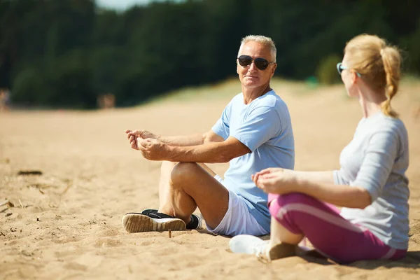 Senior Férfi Felesége Sportruházat Meditál Homok Után Reggeli Edzés — Stock Fotó