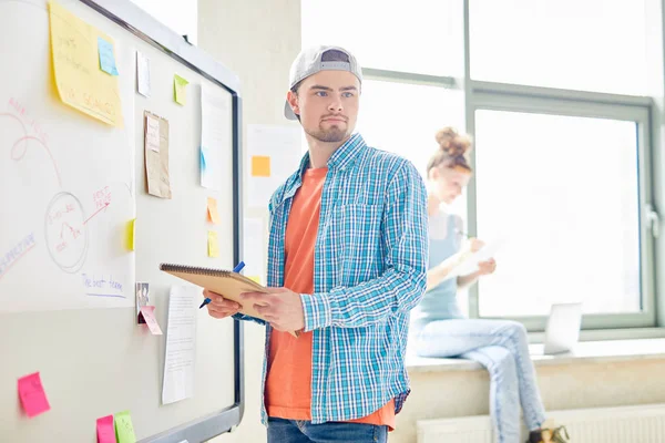 Serieuze Peinzende Student Casualwear Staande Door Whiteboard Kijkend Naar Groupmate — Stockfoto