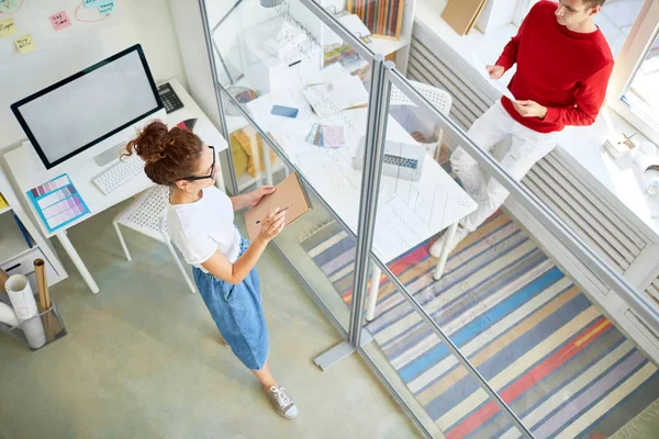 Ung Designer Med Anteckningsblock Läser Hennes Anteckningar Stående Vid Anslagstavlan — Stockfoto