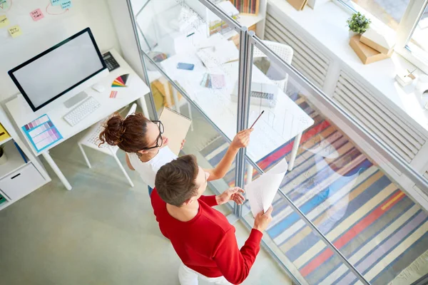 Two Young Designers Standing Transparent Noticeboard Discussing Organization Moments Office — Stock Photo, Image