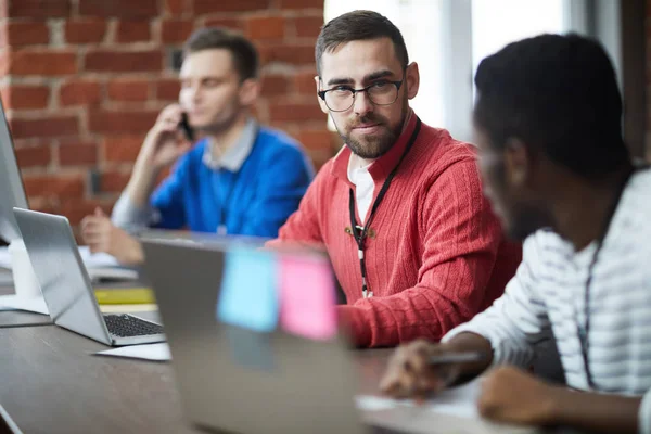 Empresário Sério Óculos Pulôver Rosa Casual Escutando Colegas Durante Discussão — Fotografia de Stock