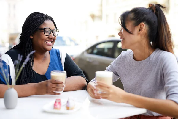 Two Cheerful Girls Casualwear Having Milkshakes While Sitting Table Cozy — Stock Photo, Image