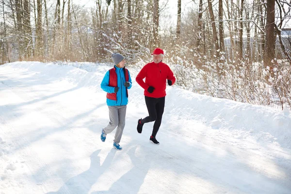 Aged Sporty Couple Having Talk While Running Snow Road Sunny — Stock Photo, Image