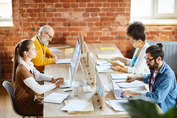 Quatro Analistas Economistas Confiantes Concentrando Seu Trabalho Enquanto Sentam Frente — Fotografia de Stock