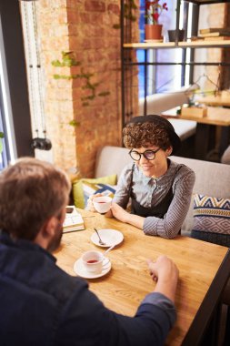 Mutlu genç sevdalı çift rahat kafe ya da Restoran oturan, çay içiyor ve planlarını tartışıyor