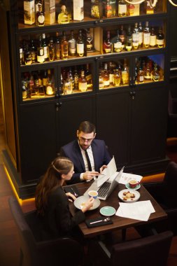 Lüks restoranda otururken tartışırken finansal kağıtları iki genç iş ortakları