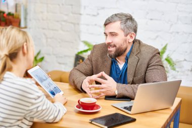 Kendine güvenen broker meslektaşım çizelgesini kafede çalışma toplantısında Mali oranı açıklayan