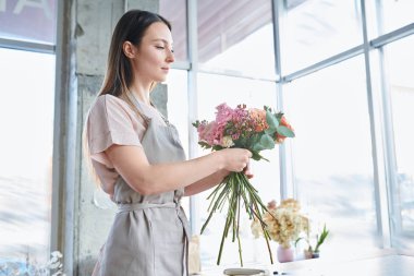 Genç kadın önlük pastel renk Çiçek çiçekçi dükkanı veya studio grup ile çalışma