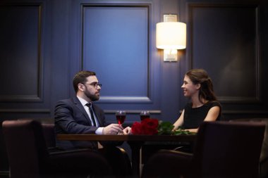 Tablo karşısında başka bir restoranda akşam yemeği talk tadını çıkarırken tarafından oturan genç romantik randevular