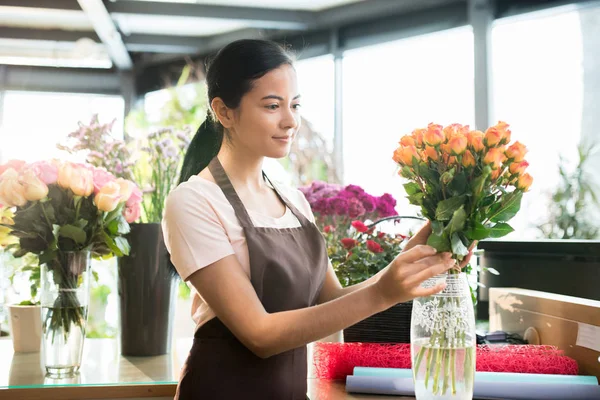 Ganska Ung Brunett Kvinna Arbetskläder Sätta Färska Orange Rosor Vas — Stockfoto