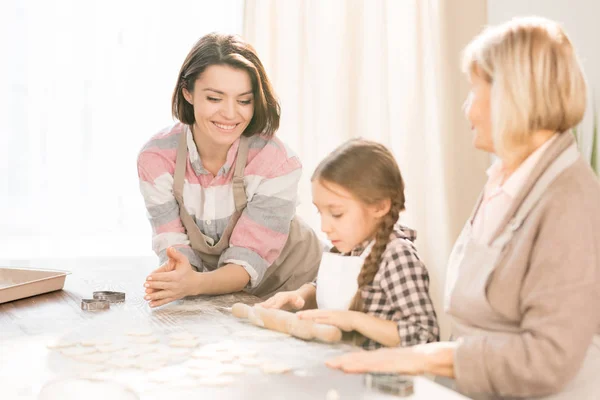 可爱的小女孩之间的妈妈和奶奶使用滚针 使面团片平之前 使饼干 — 图库照片
