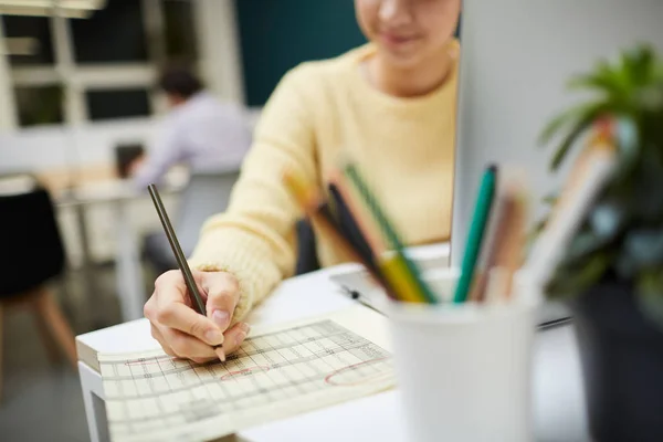 年轻的会计在计算办公室工作人员的工资时 用铅笔在财务文件中盘旋数字 — 图库照片