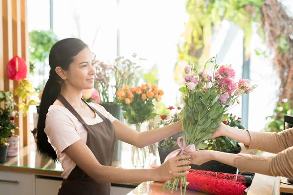 Ganska Ung Florist Arbetskläder Passerar Gäng Rosa Blommor Till Klienter — Stockfoto