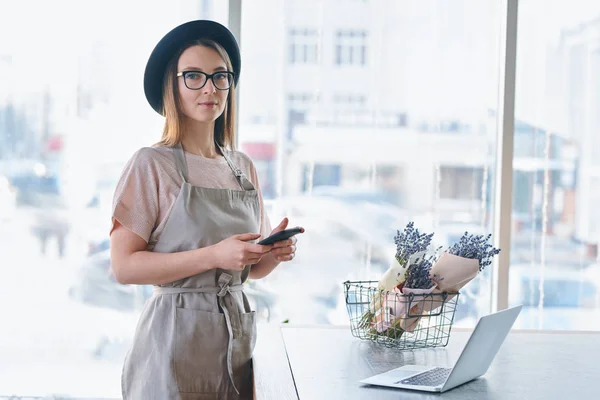 Söt Tjej Förkläde Hatt Och Glasögon Som Står Vid Bordet — Stockfoto