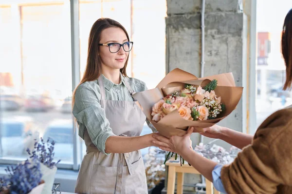 Young Woman Apron Eyeglasses Giving Big Bouquet Pastel Flowers Her — Stock Photo, Image